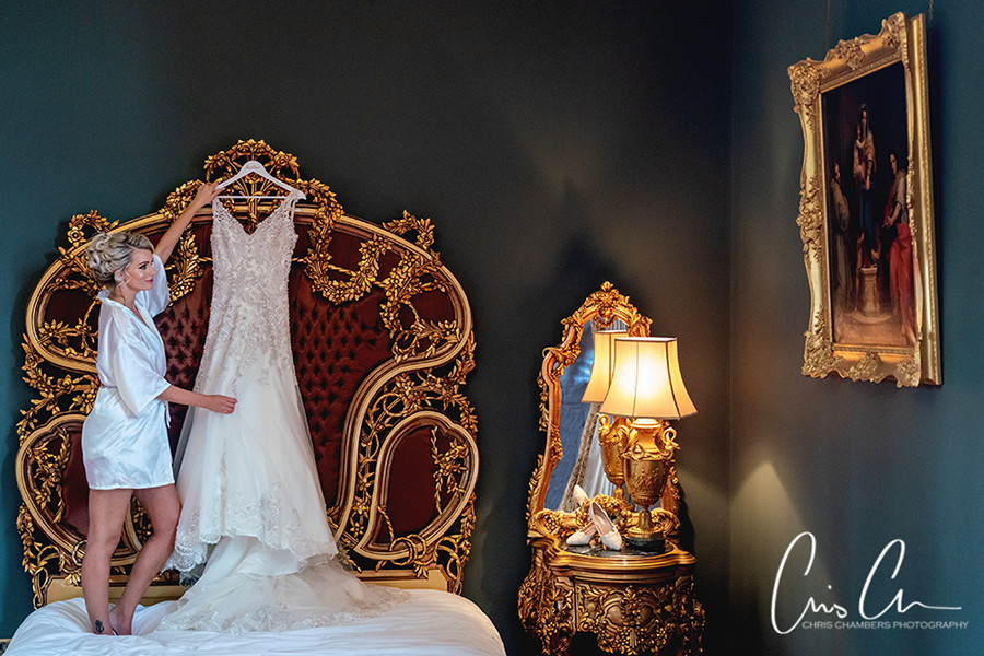 Wedding dress hanging in the Palace Suite bedroom at Allerton Castle. Yorkshire wedding photographer at Allerton Castle. 
