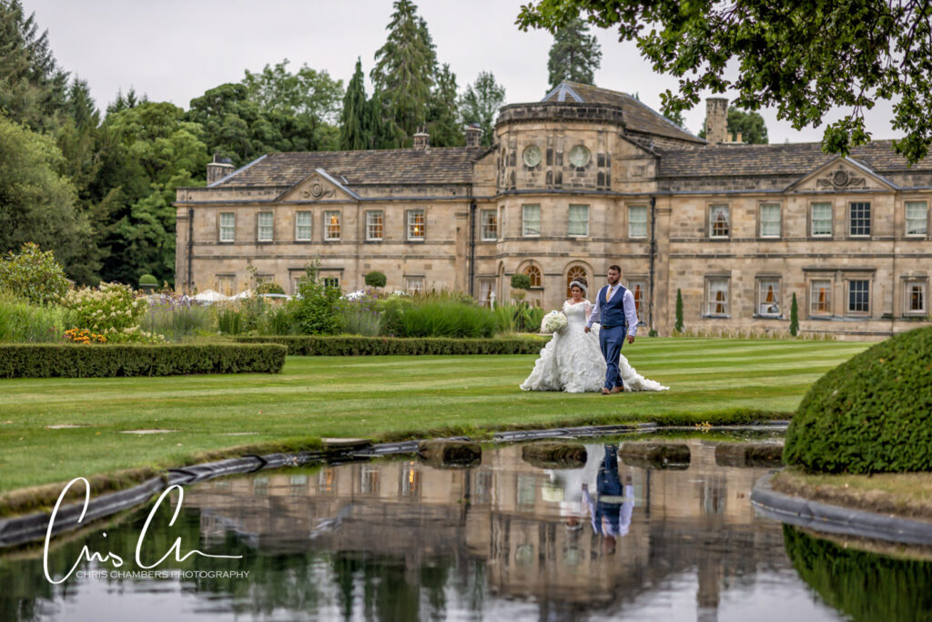 Bride and groom walk in the grounds of Grantley Hall. Luxury and exclusive wedding venue in North yorkshire