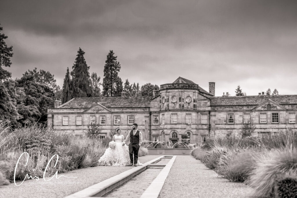 Bride and groom walk in the grounds of Grantley Hall. Luxury and exclusive wedding venue in North yorkshire