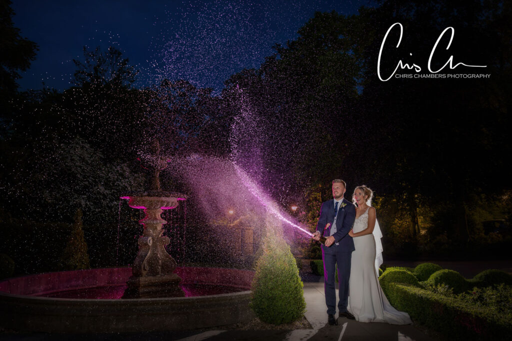 Couple with sparkling fountain at night, wedding photography. Manor House Lindley.