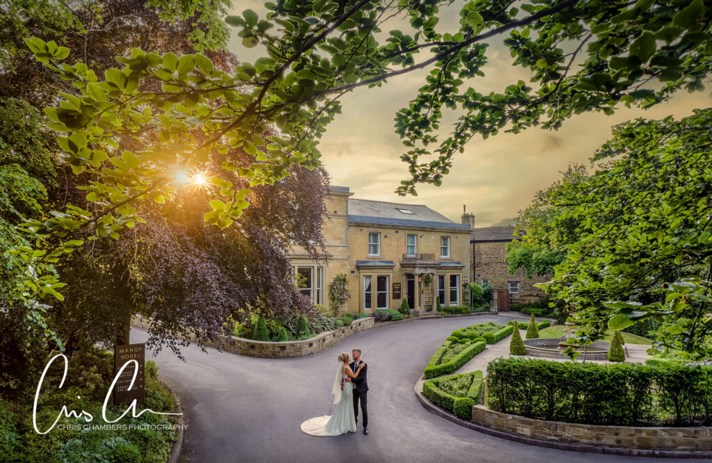 Couple embracing at sunset outside manor house Lindley wedding venue.