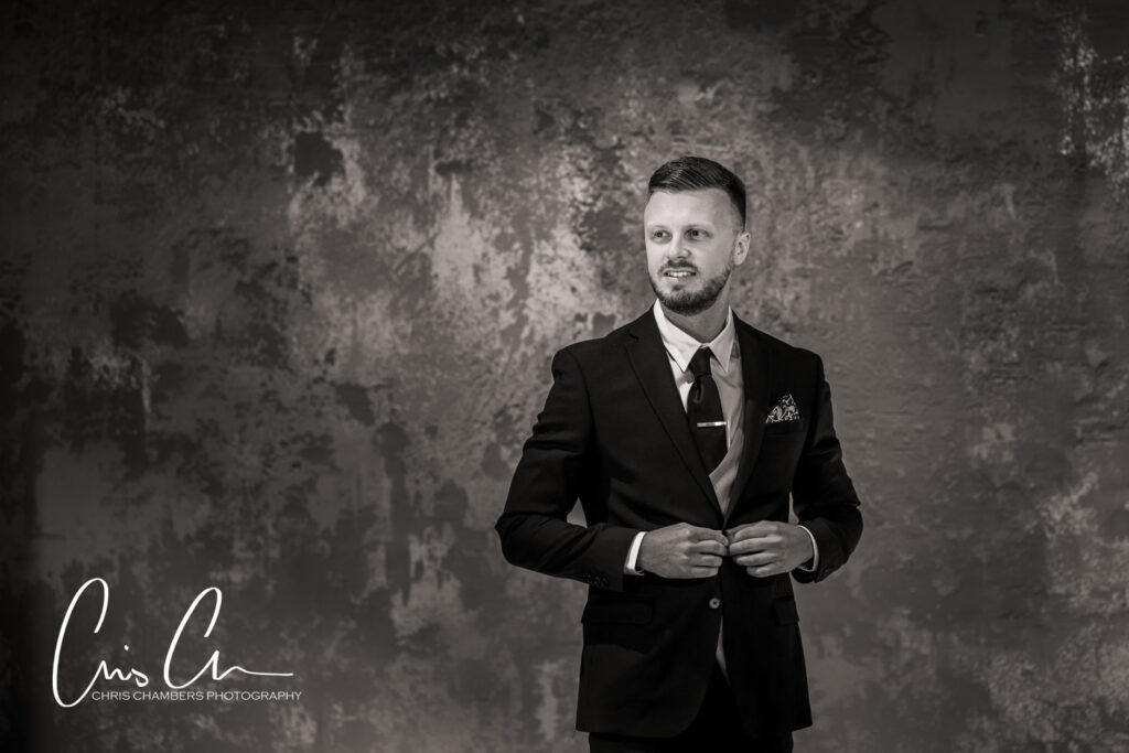 Man in suit posing for portrait, grayscale photography.