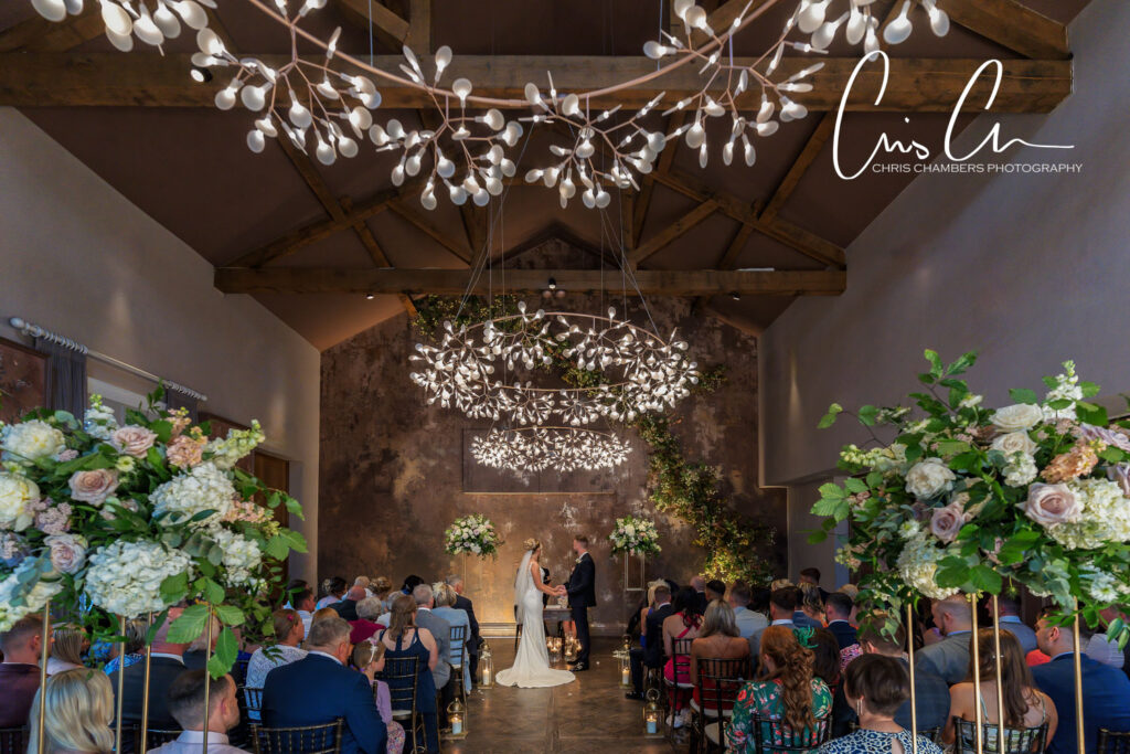 Elegant wedding ceremony in a rustic venue with guests.