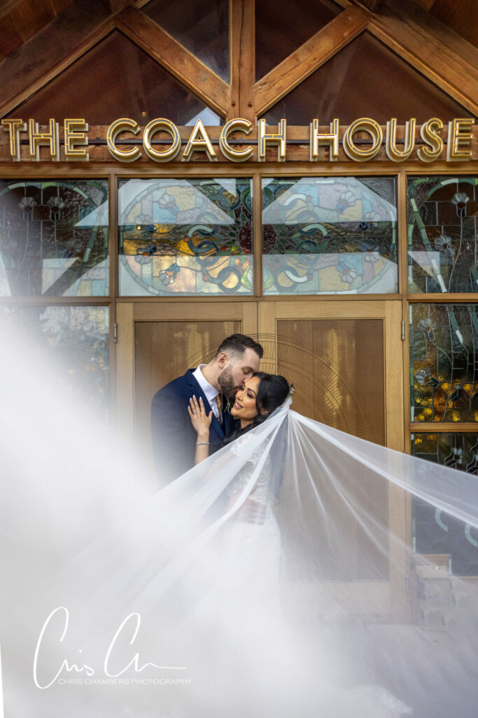 Couple embracing outside Coach House at the Manor House Lindley