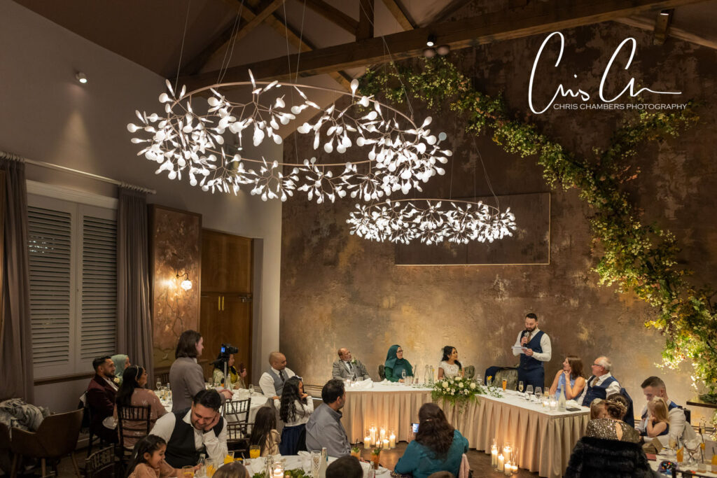 Elegant wedding reception with guests and decorative lighting in the coach house at Manor House Lindley.