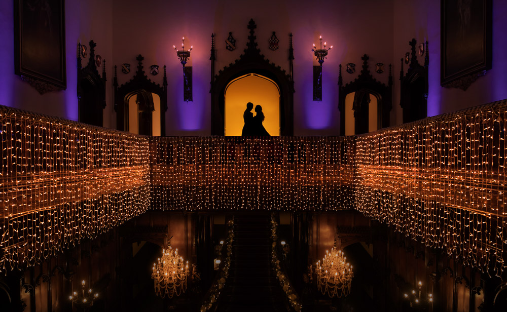 Silhouetted bride and groom on the gallery at Allerton Castle in North Yorkshire