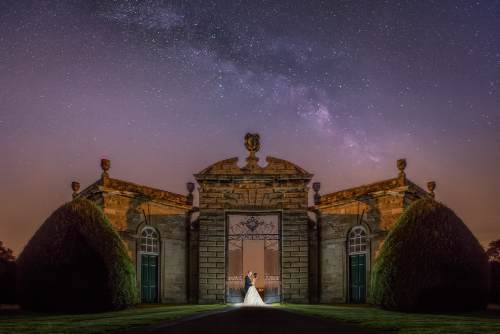 Bride and groom in the entrance way with the Milky Way above them. Yorkshire wedding photographer Chris Chambers