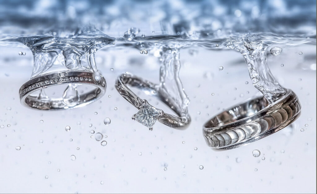 Wedding rings submerged in water with air bubbles. Chris Chambers Yorkshire wedding photographer