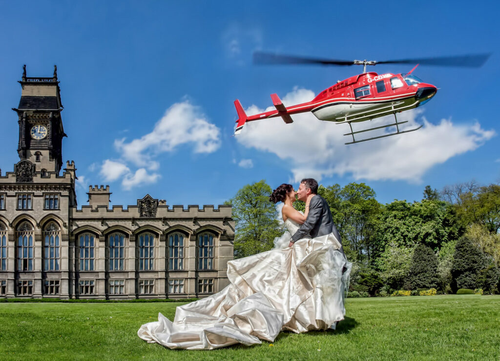 Wedding couple kissing, helicopter flying overhead and Carlton towers in the background