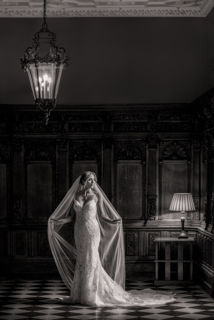 Bride and long veil in the Flemish Hall at Hazlewood Castle Yorkshire