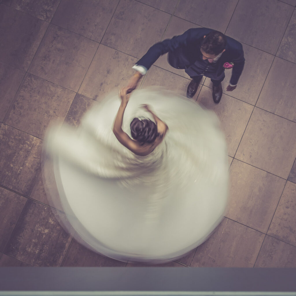 Couple dancing at wedding, blurred motion effect.