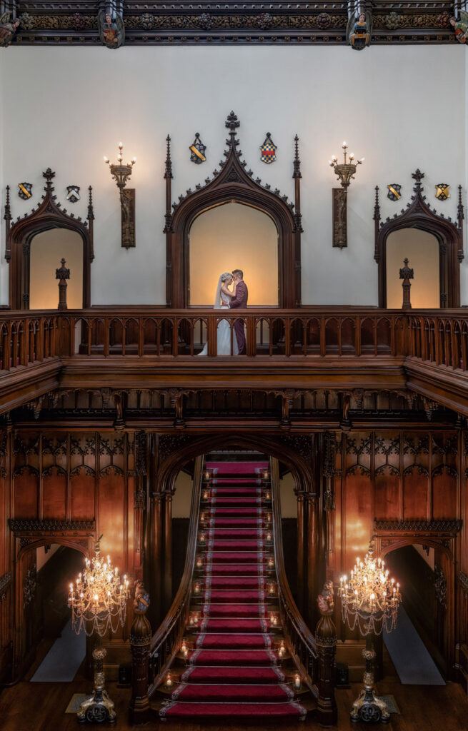 Bride and groom pose on the gallery at Allerton castle North Yorkshire