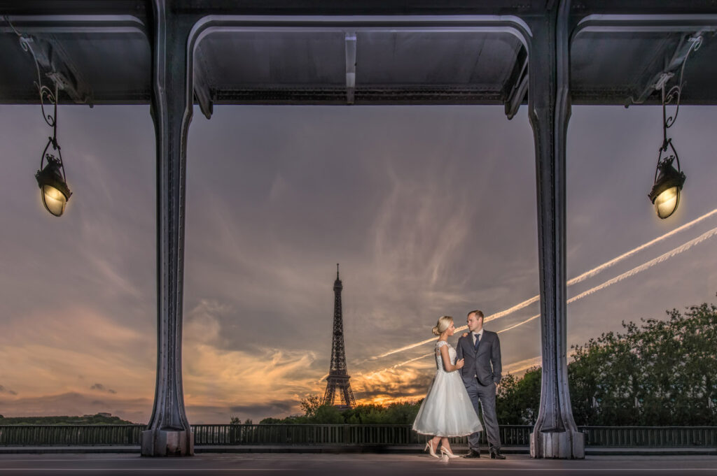 Couple posing near Eiffel Tower at sunset. Pont Bir Hakeim Paris.
