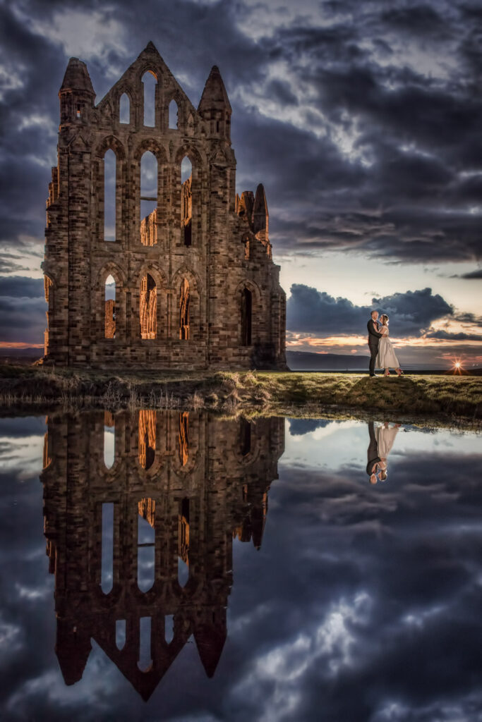Couple pose near Whitby Abbey in North Yorkshire at sunset