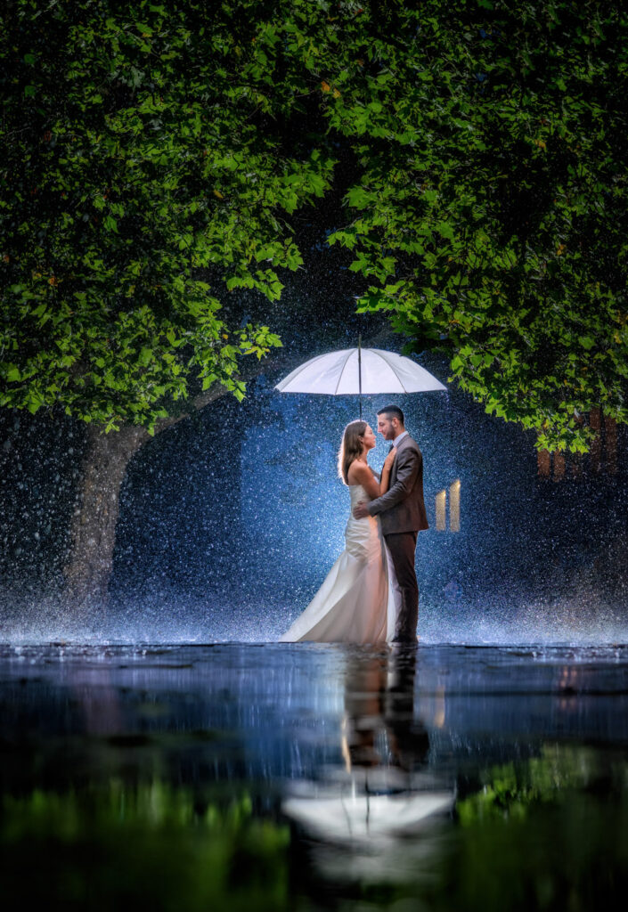 Couple embracing under umbrella in the rain on a stormy day.
