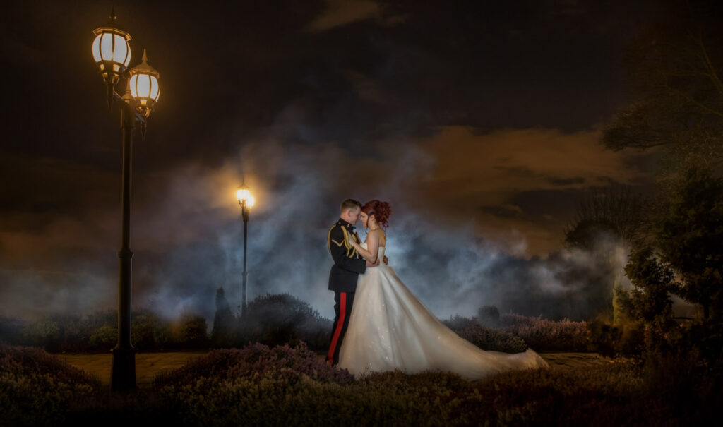 Couple embracing in misty, lamp-lit garden at night at Waterton park Hotel Wakefield