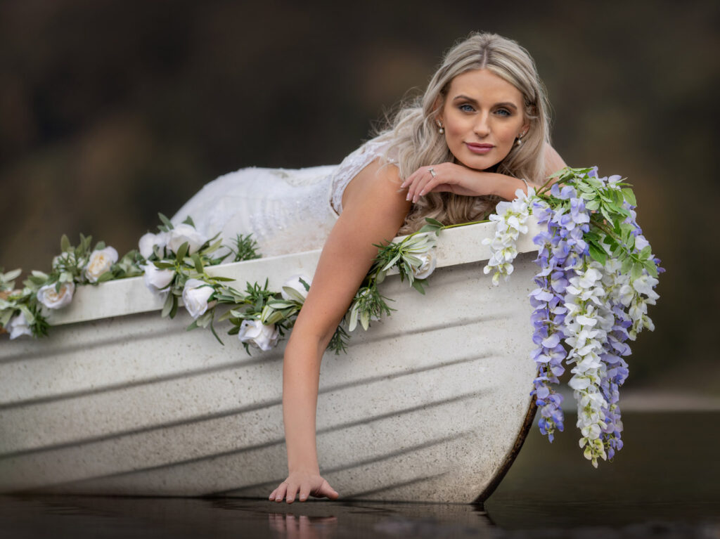 Bride posing in decorated boat with flowers