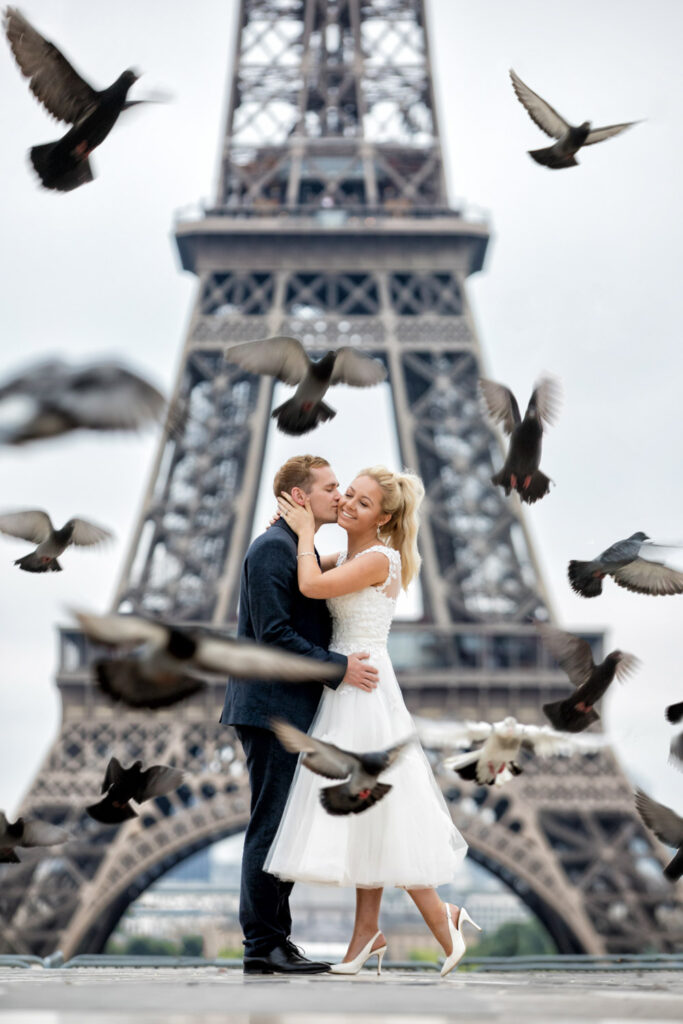 Couple kissing by Eiffel Tower with flying pigeons. Chris Chambers Yorkshire wedding photographer