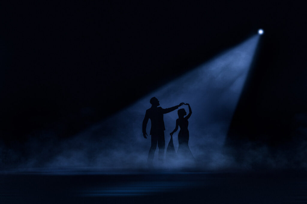 Silhouetted couple dancing under spotlight with mist. Chris Chambers Yorkshire wedding photographer