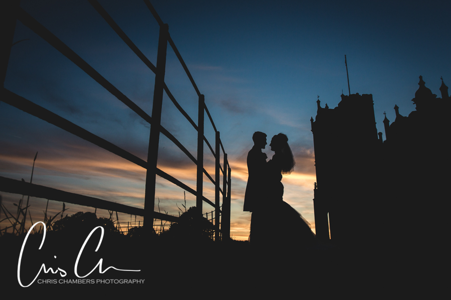 Sunset at Allerton Castle North Yorkshire. Bride and groom silhouetted against the sunset with the castle in the background