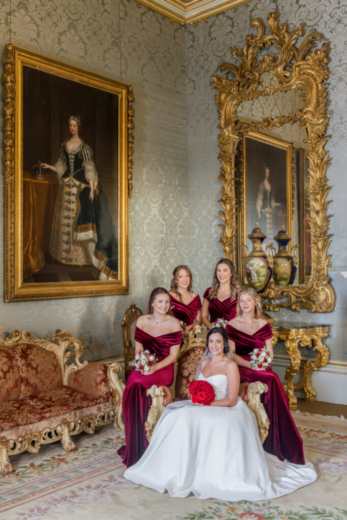 Bride and bridesmaids in elegant room with antique decor.