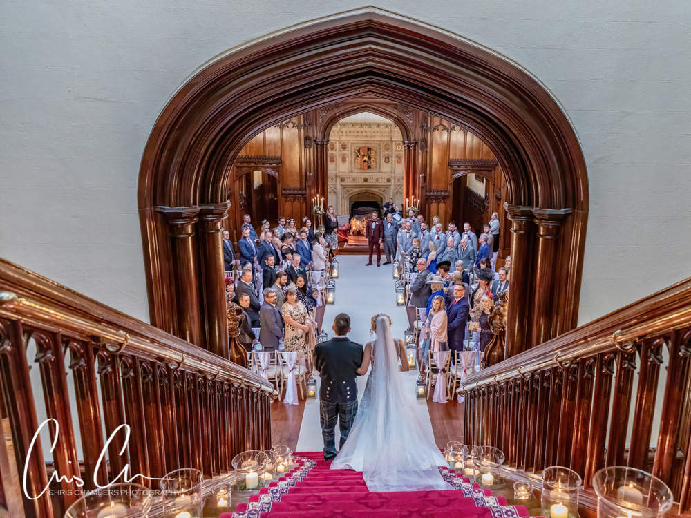 Bridal entrance into the wedding ceremony down the grand staircase at Allerton Castle North Yorkshire. 