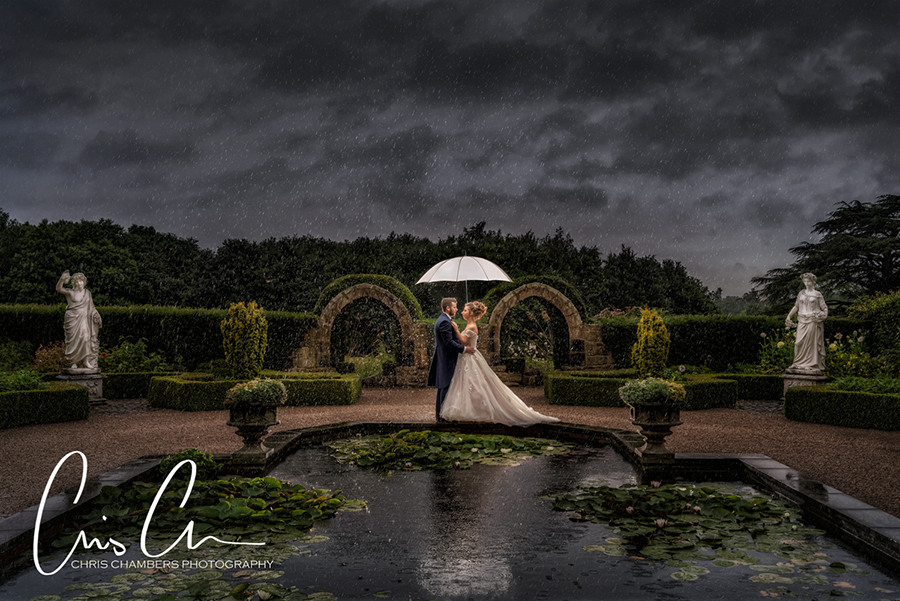 Bride and groom in the rain at Allerton Castle, North Yorkshire wedding venue potographed by recommended photographer Chris Chambers. 