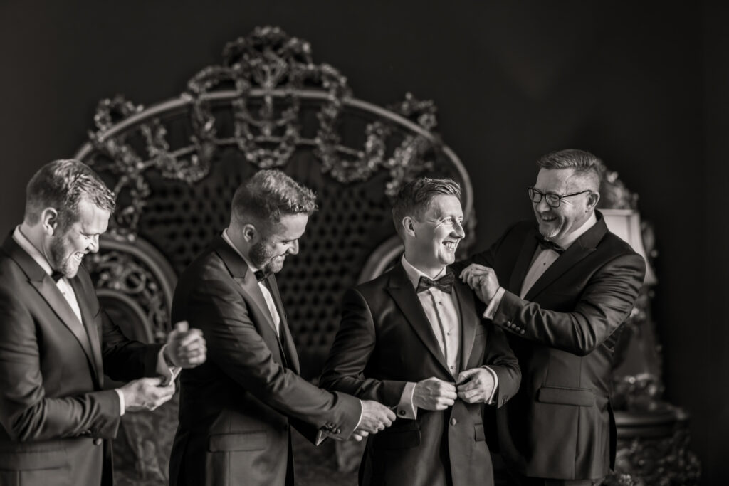 Groomsmen sharing a laugh in suits Allerton Castle wedding photographs