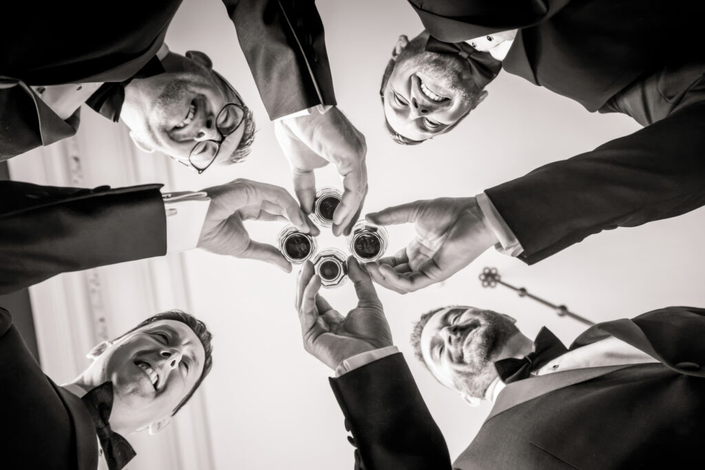 Group of men toasting in suits from below. Allerton Castle wedding photographs