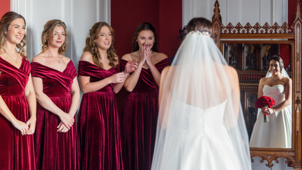 Bride and bridesmaids in red dresses, wedding preparation moment. Allerton Castle wedding photographs