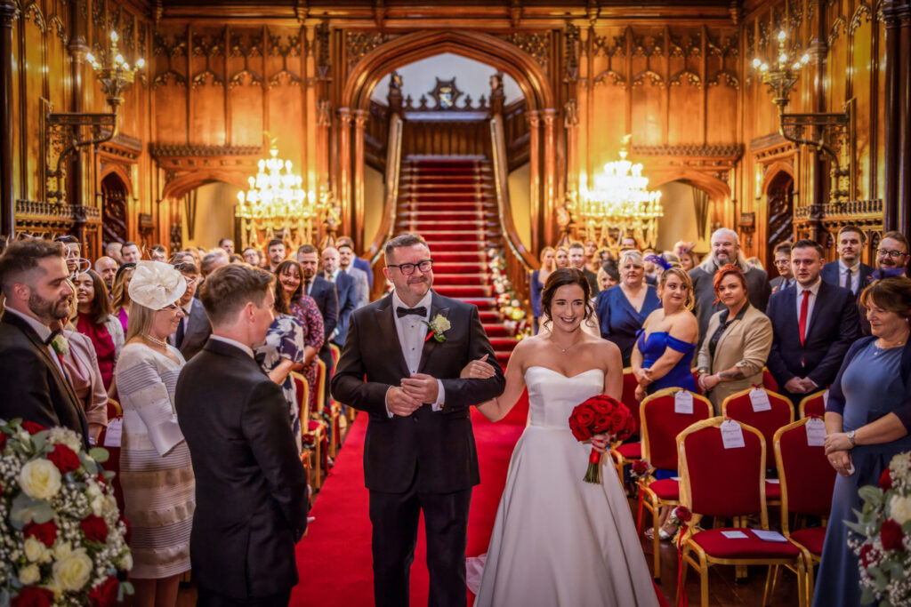Bride and father walking down the ailse. Wedding ceremony in the Great Hall at Allerton Castle. Wedding Photography from Chris Chambers