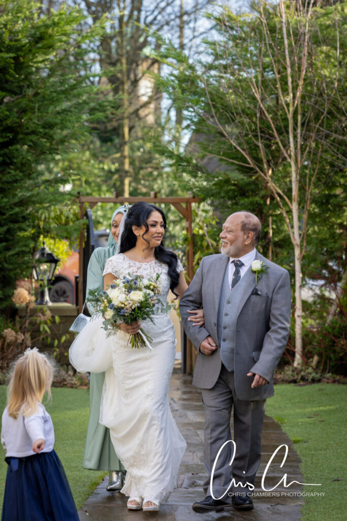 Bride walking with father, outdoor wedding ceremony. Manor House Lindley weddings.