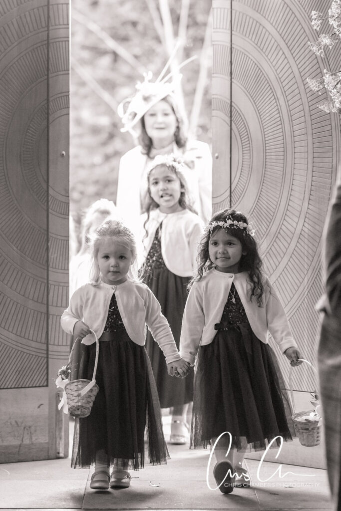 Flower girls walking hand-in-hand at wedding ceremony. Manor House Lindley weddings.