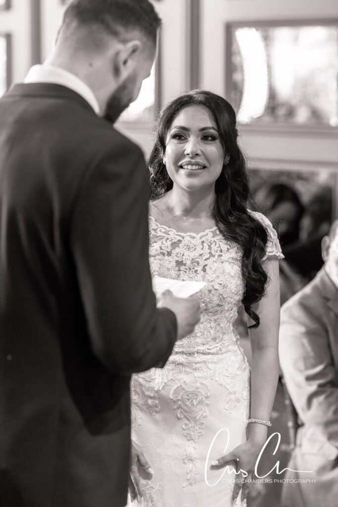 Bride smiling at groom in black and white wedding photo. Manor House Lindley weddings.