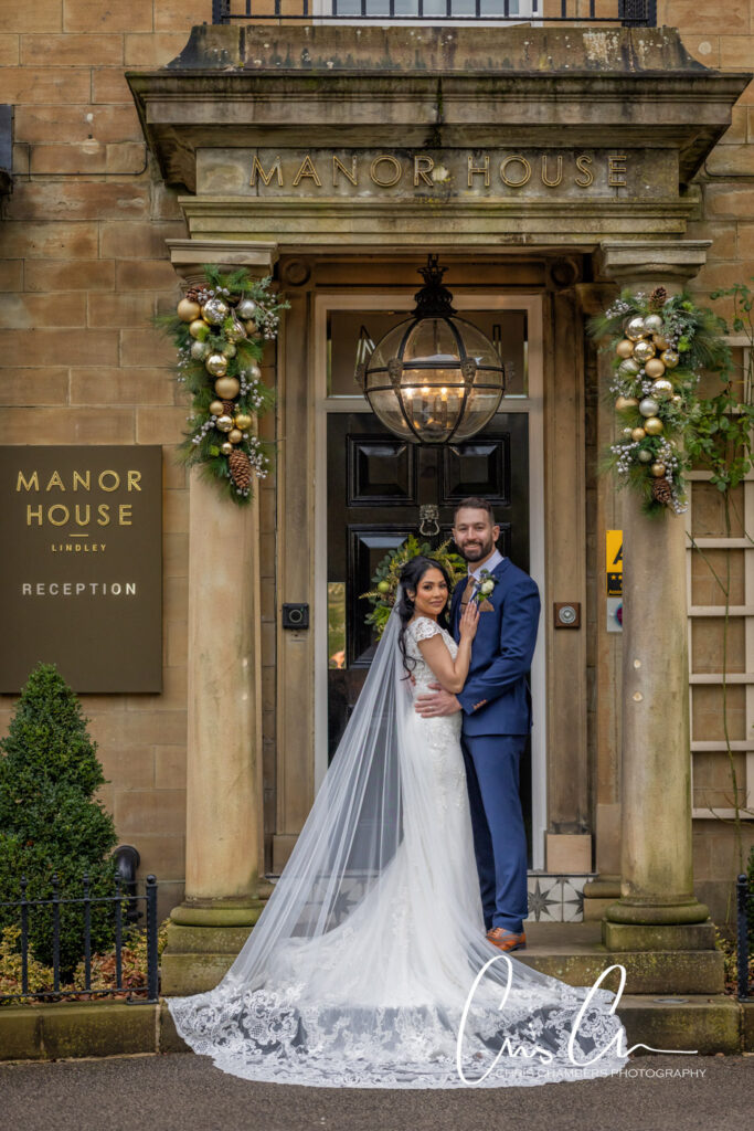 Manor House Lindley weddings. Couple posing at manor wedding entrance.