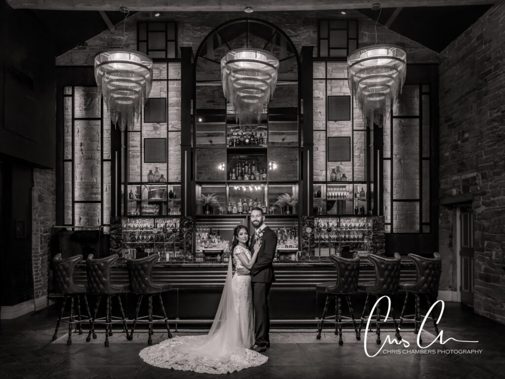Couple posing in elegant black and white bar.Manor House Lindley weddings.