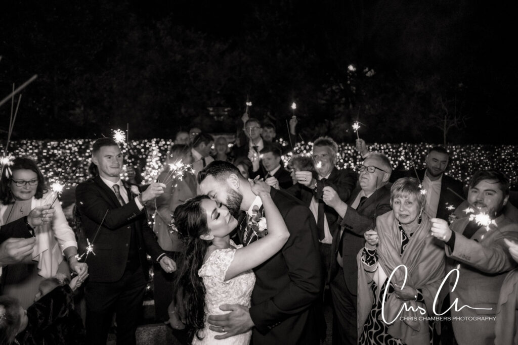 Manor House Lindley weddings. kissing at sparkler-lit wedding celebration.