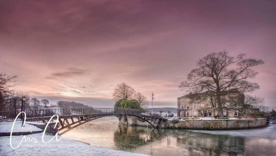 A winter scene, Walton Hall,  the island and bridge with snow and a pink winter sky