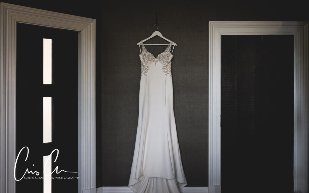 Elegant wedding dress hanging between open doors. Manor House Lindley weddings