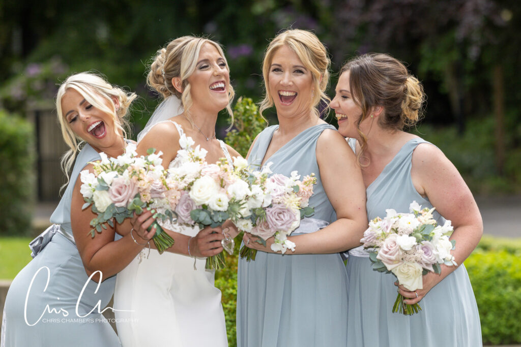Bride and bridesmaids laughing with bouquets at Manor House Lindley