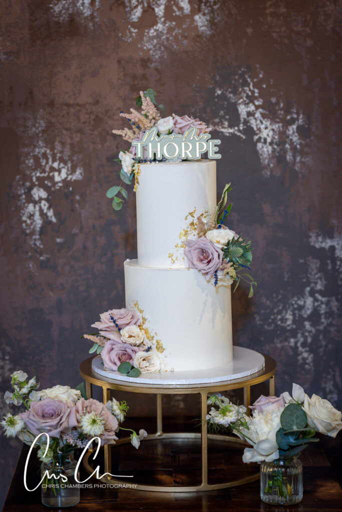 Elegant white wedding cake with floral decoration. Manor House Lindley Wedding Photographs