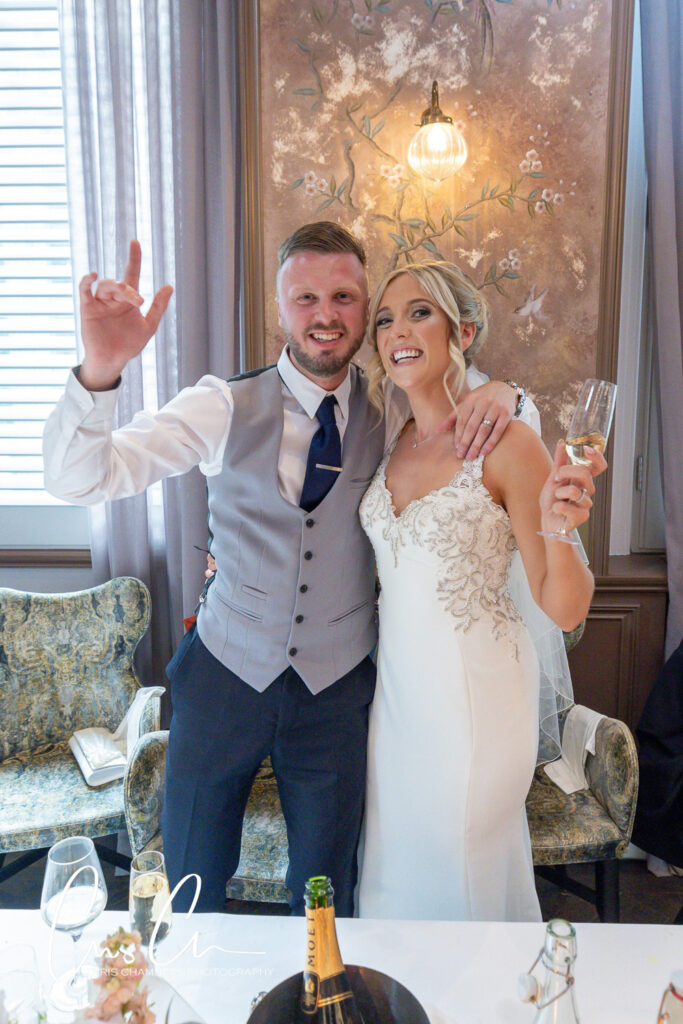 Wedding couple toasting with champagne indoors. Manor House Lindley Wedding Photographs