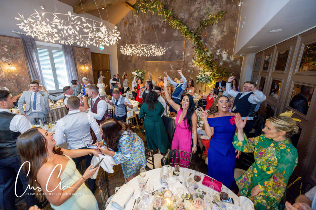 Joyful wedding reception guests dancing. Manor House Lindley Wedding Photographs