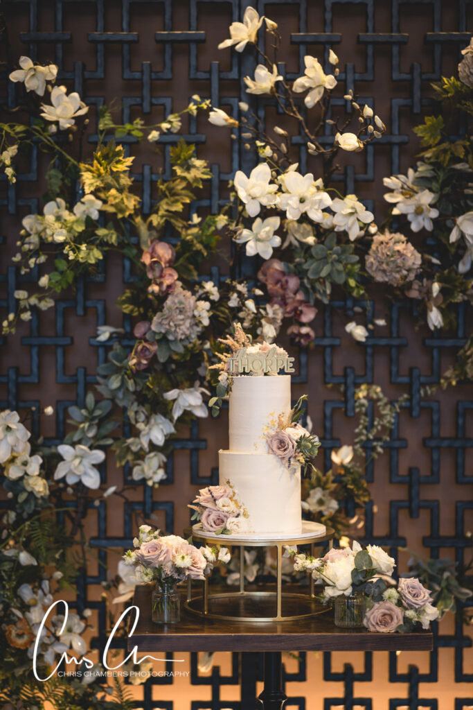 Elegant wedding cake with floral decoration on lattice background. Manor House Lindley Wedding Photography