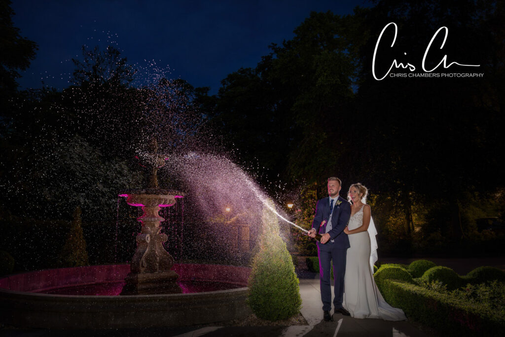 Bride and groom with illuminated fountain at night wedding photograph at Manor House Lindley