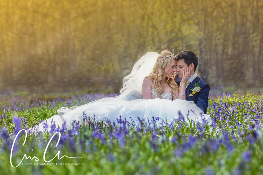 Hazlewood Castle Wedding Photography. Bride and groom embracing in bluebell field.