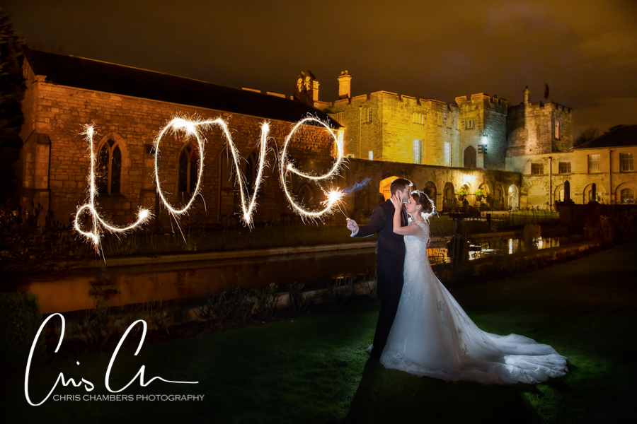 Hazlewood Castle Wedding Photography. Couple with sparkler love sign at night wedding.