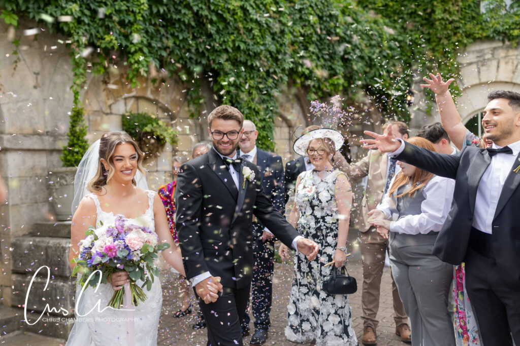wedding confetti, the bride and groom walk though the confetti at Hazlewood Castle