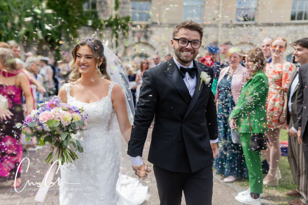 wedding confetti, the bride and groom walk though the confetti at Hazlewood Castle